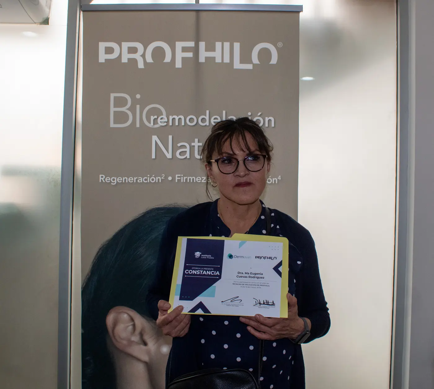 Médica egresada mostrando su constancia de taller del Instituto Láser Puebla
