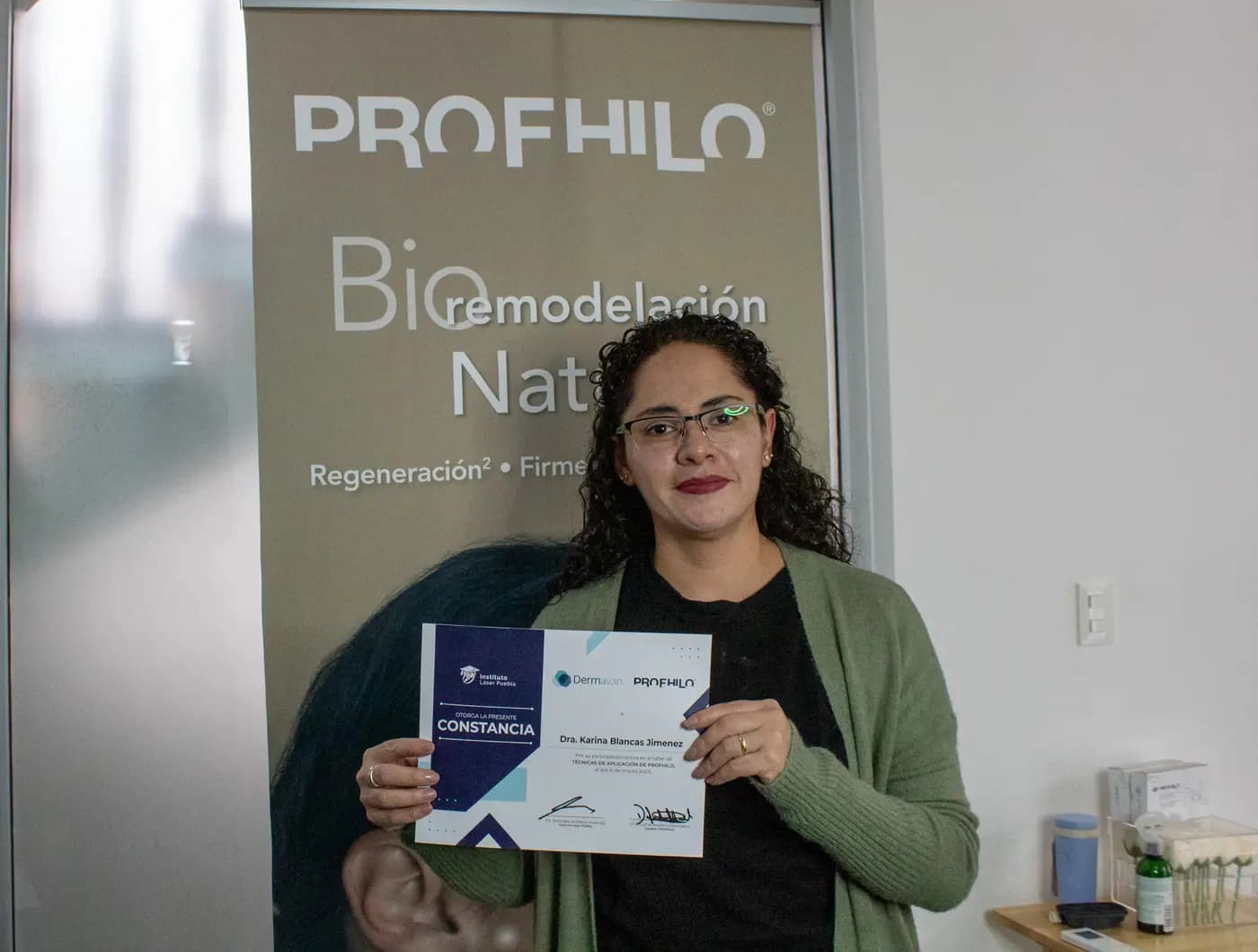 Médica egresada con su constancia de participación del Instituto Láser Puebla