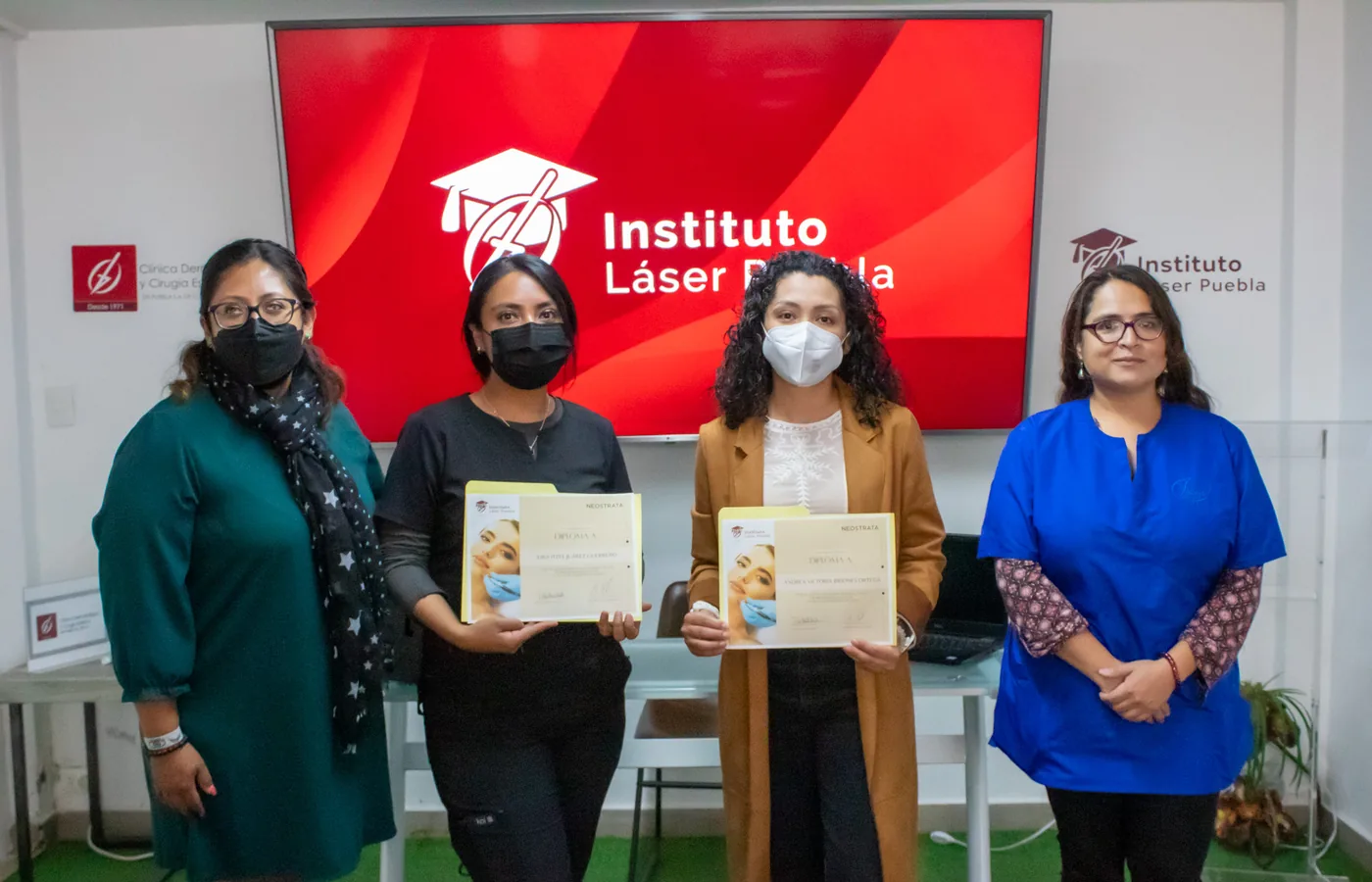Dos egresadas muestran el diploma del Diplomado en Láser Médico Quirúrgico y Dermatoestética