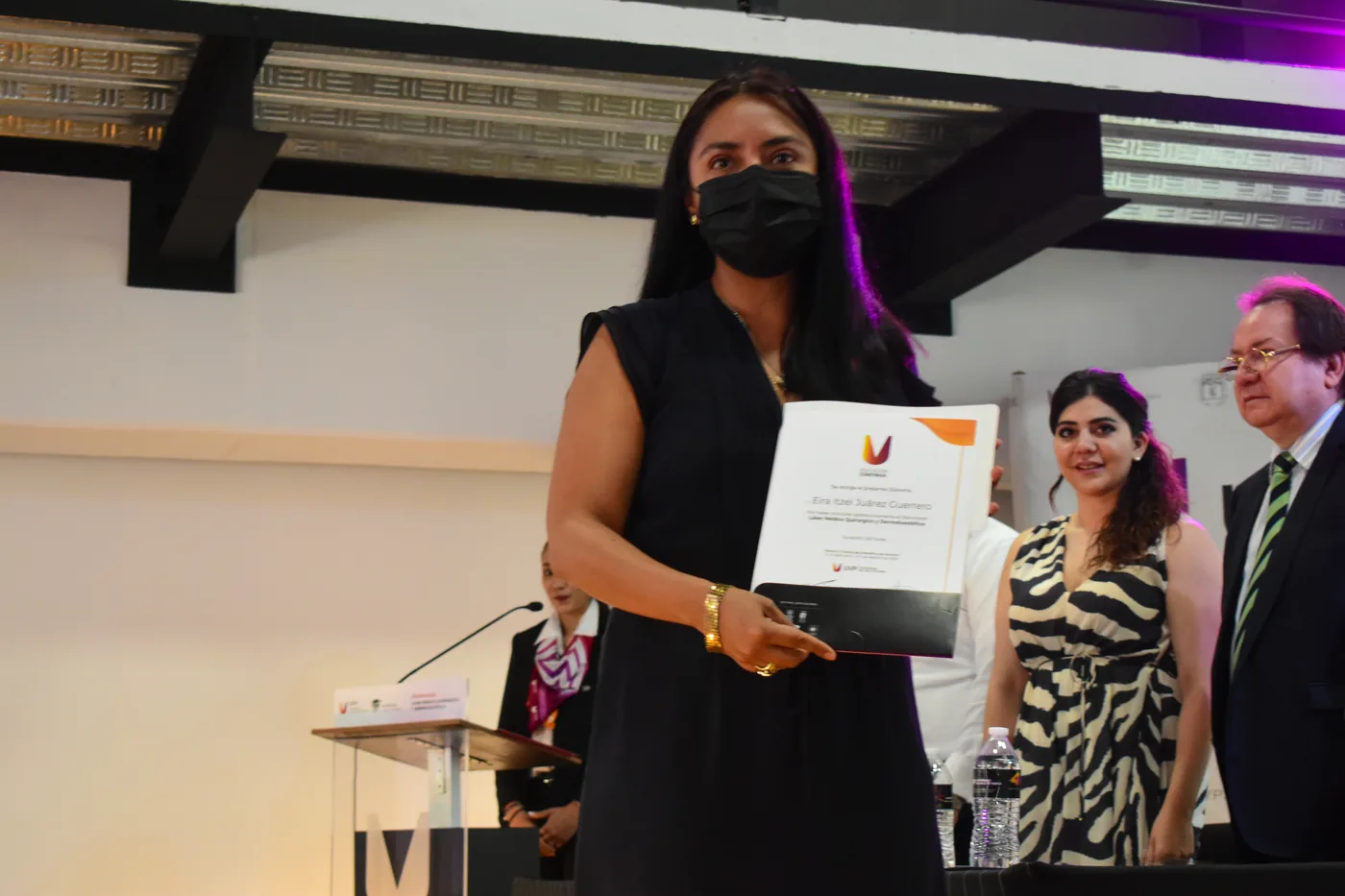 Egresada recibe su diploma durante la ceremonia de graduación