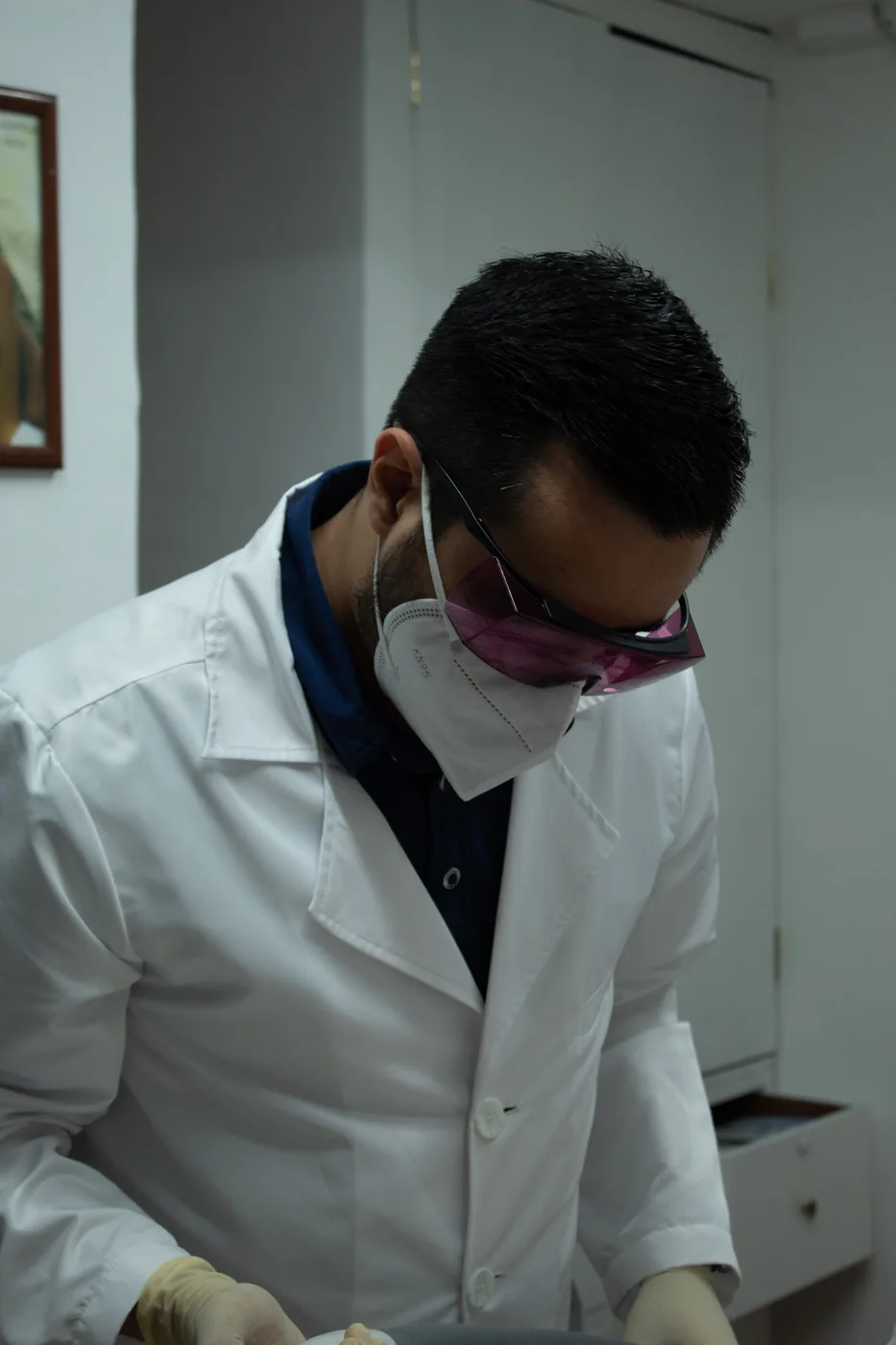 Médico operando la pieza de mano del equipo láser durante la práctica supervisada